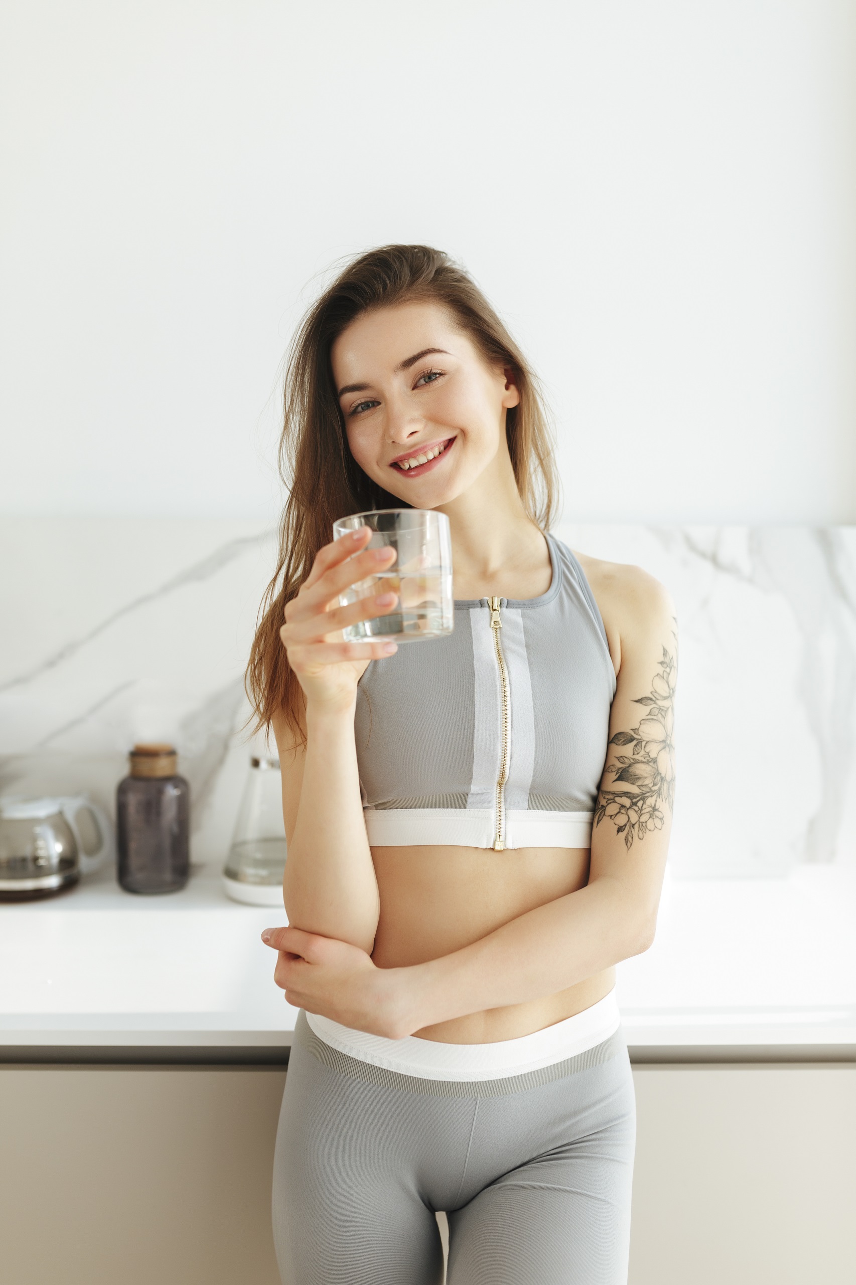 Smiling woman holding a glass of water in her kitchen